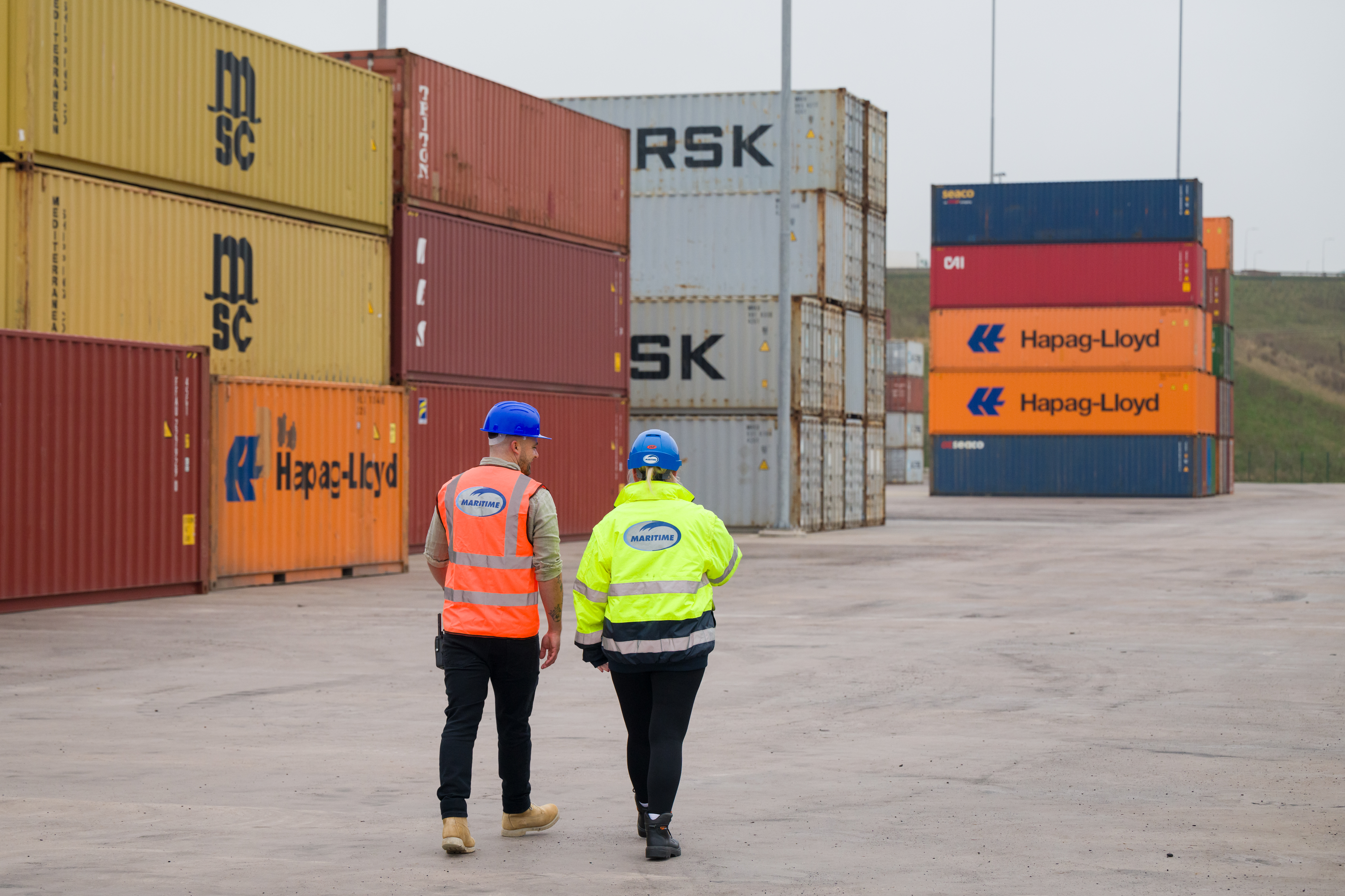 Two employees working by containers